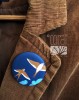 Badge motif hirondelles dans les nuages ocre et bleu